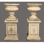 A pair of reconstituted stone garden vases and pedestals, 94cm h Minor chips and signs of weather