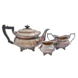 An Edwardian silver tea service, with gadrooned rim, on paw feet, 15cm h, by Thomas Bradbury & Sons,