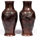 A pair of Japanese bronze vases, Meiji period, decorated in relief with birds on prunus, russet