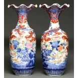 A pair of Japanese Imari vases, Meiji period, the flared neck with undulating rim, painted with