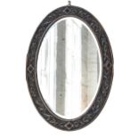 An oval mirror, with bevelled plate in carved oak frame, 89 x 64cm