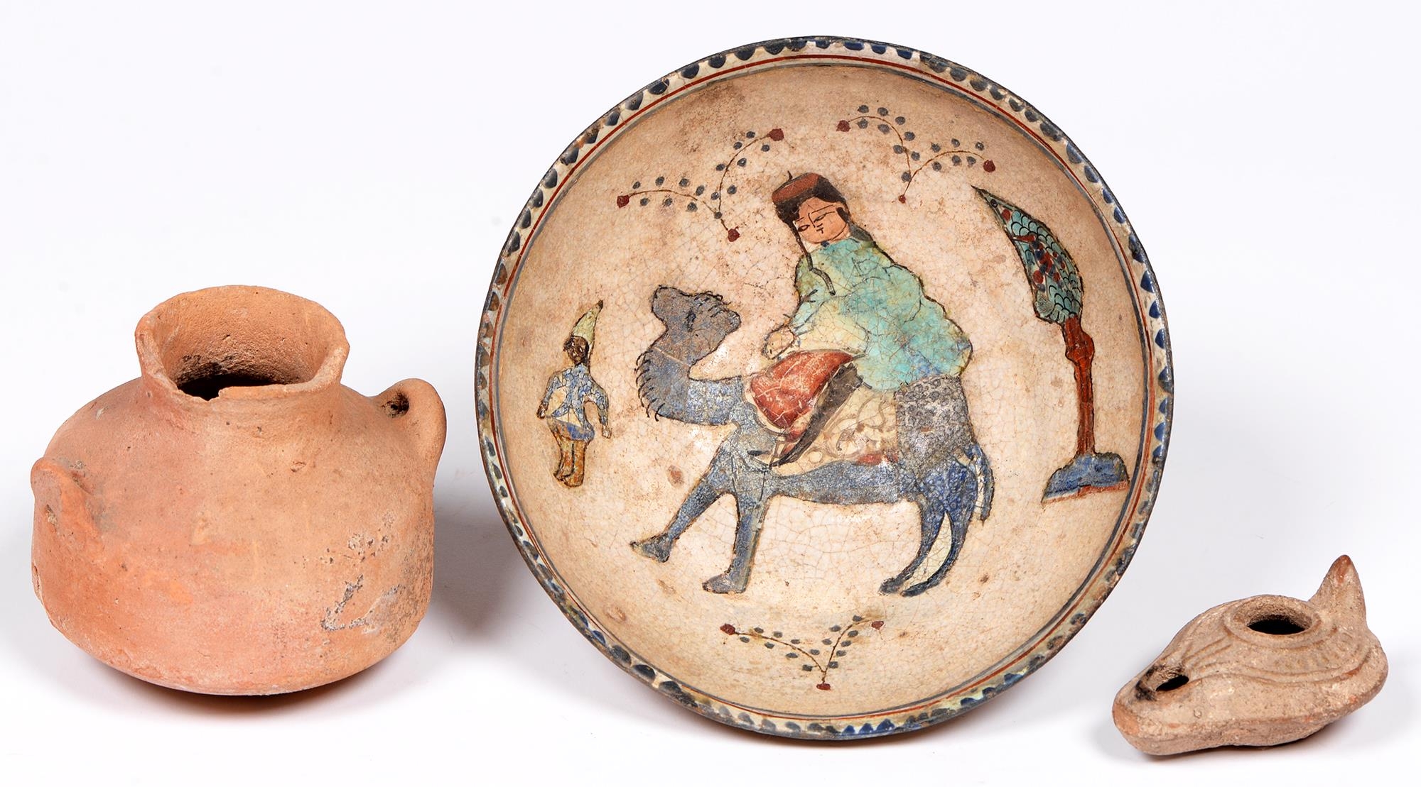 A Persian earthenware bowl, the painted and glazed interior with a figure on a camel, 17cm diam, a