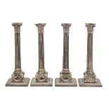 A set of four Victorian EPNS column candlesticks, the square foot embossed with ram's heads and