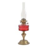 An Art Nouveau brass oil lamp, with faceted cranberry glass fount and Hinks's patent duplex