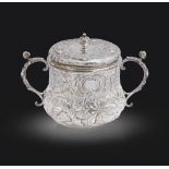 A Charles II silver porringer and cover, decorated in punchwork and chased in high relief with