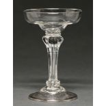 An English champagne or sweetmeat glass, c1750, the ogee bowl on moulded pedestal stem between
