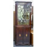 An Edwardian mahogany standing corner cabinet, with shell paterae, the lower part enclosed by