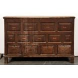 A George III oak mule chest, with raised and fielded panels to the front and drawers, on stiles,