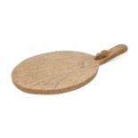 A Robert 'Mouseman' Thompson oak cheeseboard, the handle with carved mouse 'signature', 36.5cm l Not