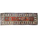 An antique Caucasian runner, 110 x 335cm Worn and threadbare in places