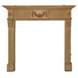 A neo classical style pine chimneypiece, with festoon tablet flanked by paterae,   131 cm h, 143cm l