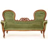 A Victorian carved serpentine walnut sofa, with twin arched chair backs divided by pierced and