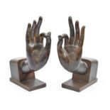 A pair of South East Asian bronze sculptures of the hands of Buddha,  mounted on stained wood,