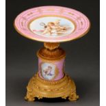 A French gilt brass mounted porcelain tazza, late 19th c, painted with putti in cisele reserves on a