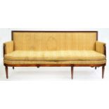 A George IV mahogany settee, with channelled frame and reeded tapering pillars to the arms,