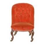 A Victorian nursing chair, on carved walnut legs with brass castors Buttoned upholstery faded and