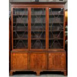 A Victorian mahogany bookcase, fitted with shelves enclosed by three glazed doors, the lower part