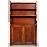 A Victorian mahogany 'waterfall' bookcase, the lower part enclosed by panelled doors flanked with