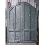 A substantial pair of Victorian green painted four panel wood arched doors,  259 h,  185cm l In