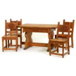 An English Arts & Crafts oak dining table and four chairs, c1950,  the table with cleated ends and