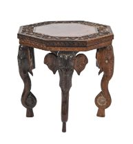 An Indian rosewood table, early 20th c, the carved octagonal top with floral border on four elephant