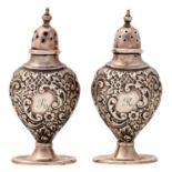 A pair of Edwardian silver die stamped pepperettes, of vase shape, 95mm h, marks rubbed,