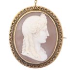 A Victorian Etruscan revival cameo brooch, the oval shell carved with the head of a classical woman,