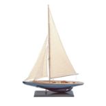 A varnished and painted wood model of a yacht, with mast, sails and riggings, on rectangular base,