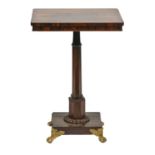 A rosewood and ebonised lamp table, 19th c, the octagonal pillar on rectangular base and brass paw