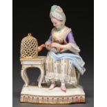 A Meissen allegorical figure of a woman seated beside a caged bird, mid 19th c after the original