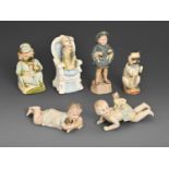 Three Continental biscuit porcelain zoomorphic pug dog nodding figures, two similar piano dolls