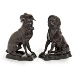 A pair of bronzed metal models of seated pug dogs in hat or bonnet, on stepped black marble resin