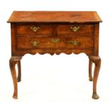A George II walnut lowboy, with oversailing quarter veneered top and fitted three drawers to the