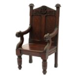 A Victorian carved and stained oak panel back armchair, with crown and sacred monogram borne on a