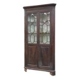 A George III mahogany standing corner cupboard, with dentil cornice and blind fret frieze, the upper