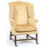 A George III mahogany wing armchair, on square legs with stretchers, brass castors Slight