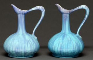 A pair of art pottery ewers, c1910, in streaked lavender blue and turquoise glaze, 20cm h Undamaged,