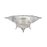 An Edwardian pierced silver sweetmeat basket, on four cast rococo feet, 25cm l, maker's mark rubbed,