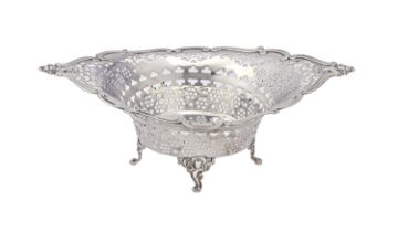 An Edwardian pierced silver sweetmeat basket, on four cast rococo feet, 25cm l, maker's mark rubbed,