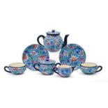 A Longwy tea service, early 20th c, with brightly coloured 'cloisonne' flowers and foliage on a