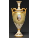 A Coalport jewelled vase, c1910, painted with an oval landscape medallion on a gilt and primrose