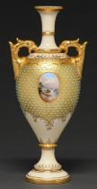 A Coalport jewelled vase, c1910, painted with an oval landscape medallion on a gilt and primrose