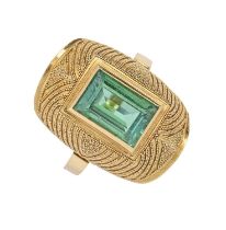 A tourmaline ring, the rectangular step cut green tourmaline in domed and beaded setting, in gold,