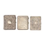 One Edwardian and two Victorian silver card cases, die stamped or engraved, leather lined, two