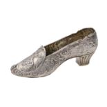 A German silver shoe shaped flower holder, cast and chased with children and flowers within