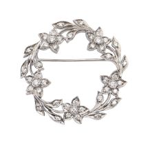 A diamond brooch, designed as a leafy circlet of flowers, millegrain set, in platinum, 38mm diam,