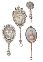 Three Continental decorative miniature silver hand mirrors and another of giltmetal, all c1900,