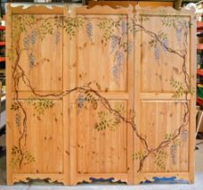 A stencilled and waxed pine screen, of three twin panelled leaves decorated with wisteria, 189 x
