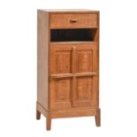 Cotswold School. An Arts & Crafts oak bedside cupboard in the manner of Peter Waals, c1930, with