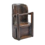 A primitive wood dug-out child's chair, possibly Wales, 18th c, 48cm h Losses and rot, some worm